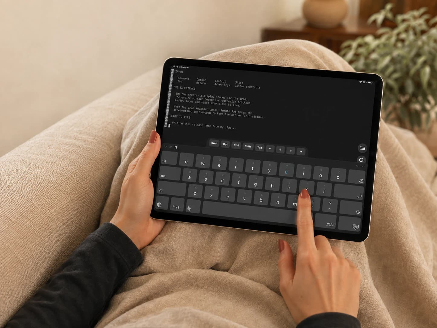 A woman typing on the iPad screen with Mac modifier keys above the keyboard